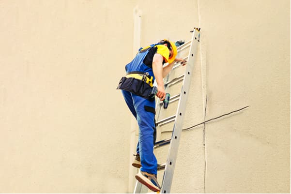 Worker on a tall ladder